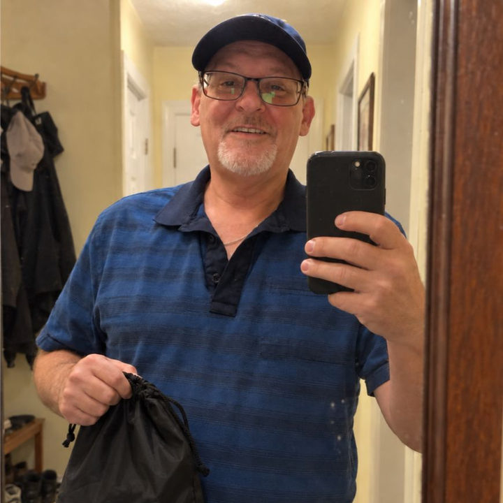 Man taking a casual mirror selfie while holding the HighPads bag