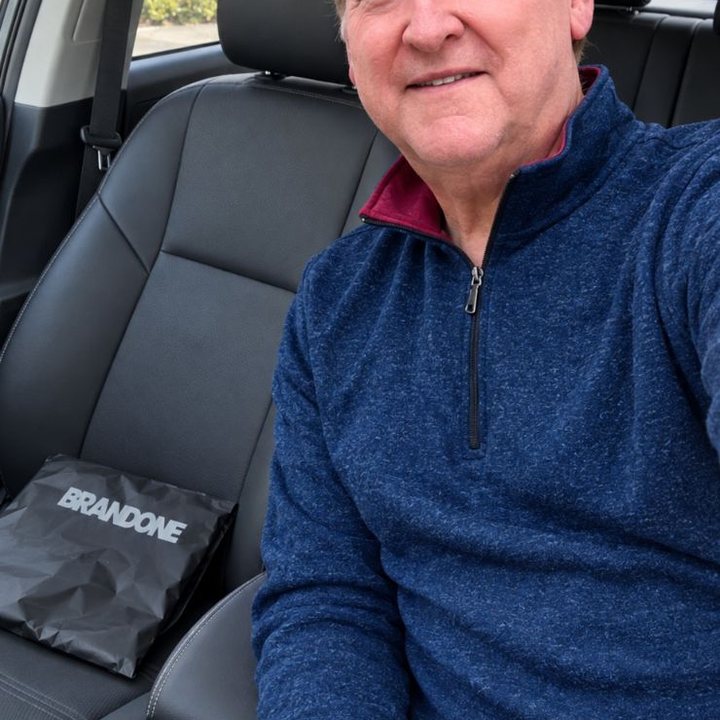 Man taking a casual selfie in his car with a HighPads bag on the seat