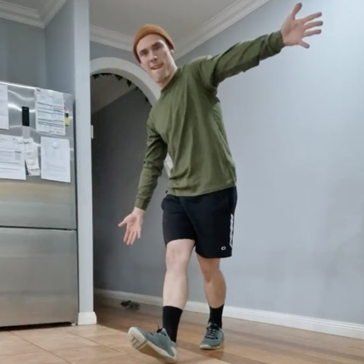 Man taking a playful step across his kitchen floor